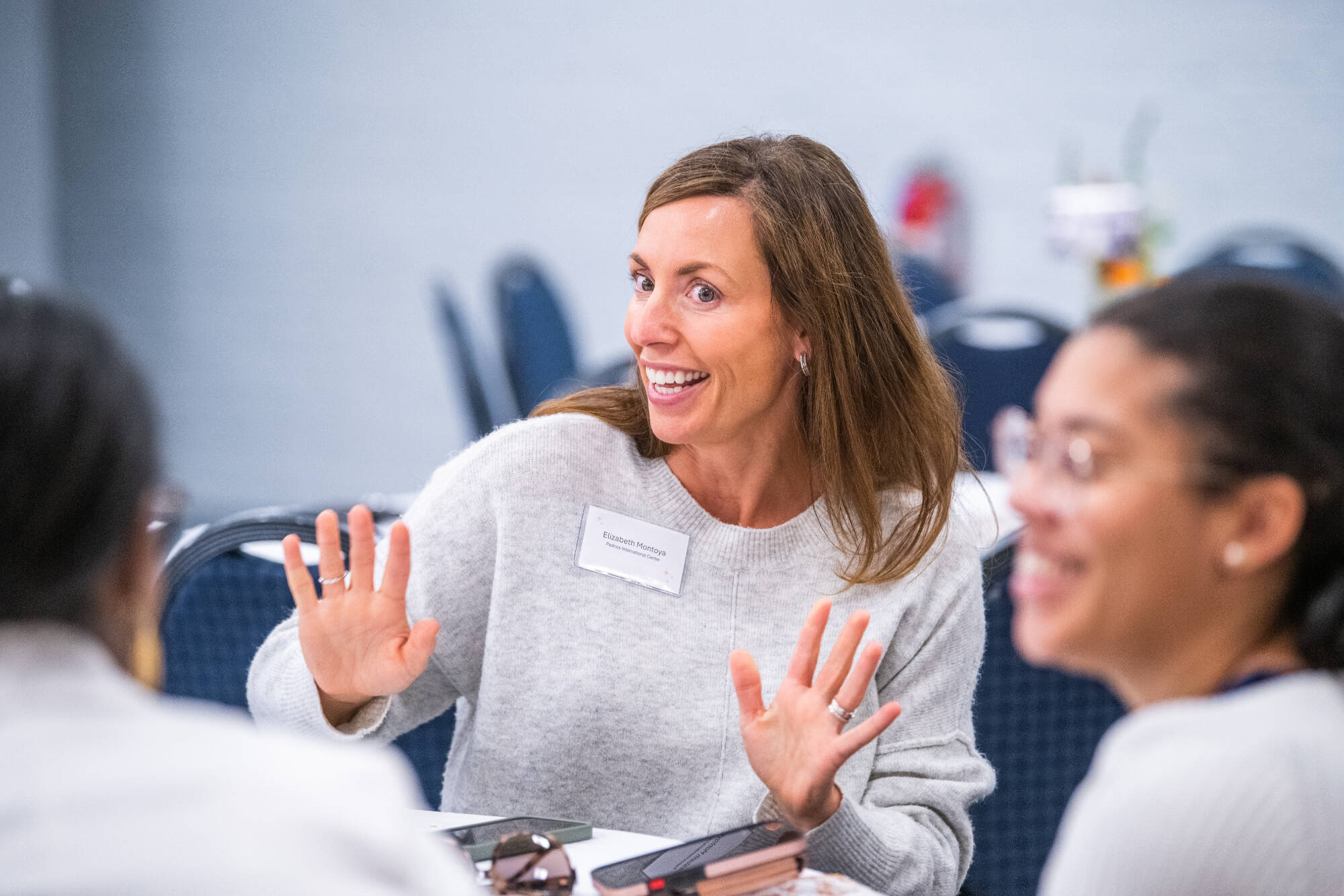 Professor Elizabeth Montoya explaining expressively at a round table discussion